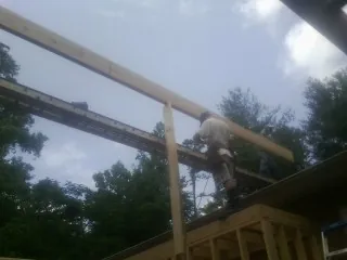 Carpenter setting a ridge beam over a new addition frame — Ice Dam Removal by Roofing Brothers in Gibsonburg