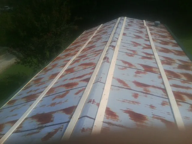 Rusted metal roof panels with new wood purlins before replacement — Storm Damage Roof Repair in Gibsonburg by Roofing Brothers