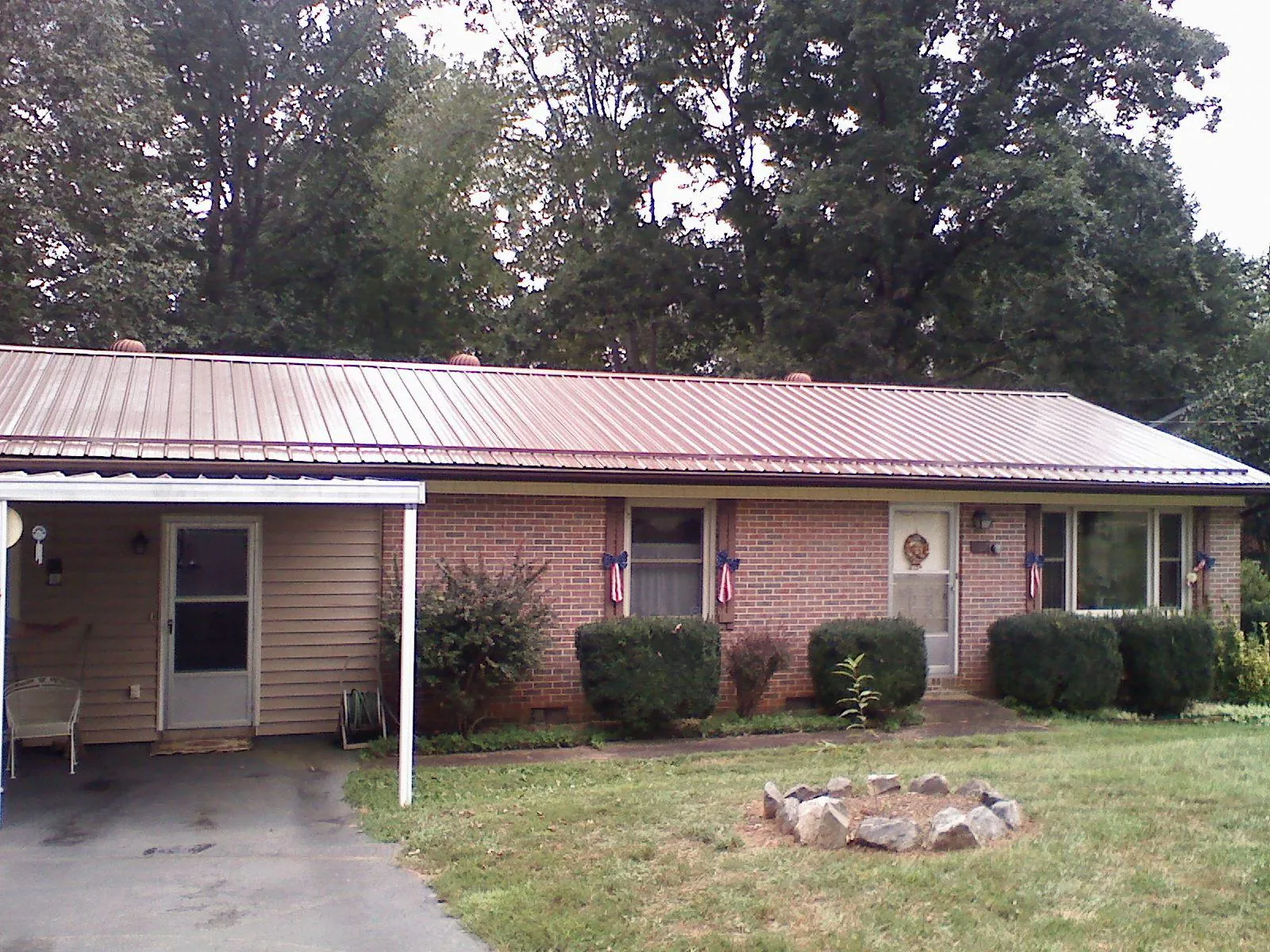 Bronze metal roof and carport on a brick ranch home — Roof Repair work by our crew in Gibsonburg